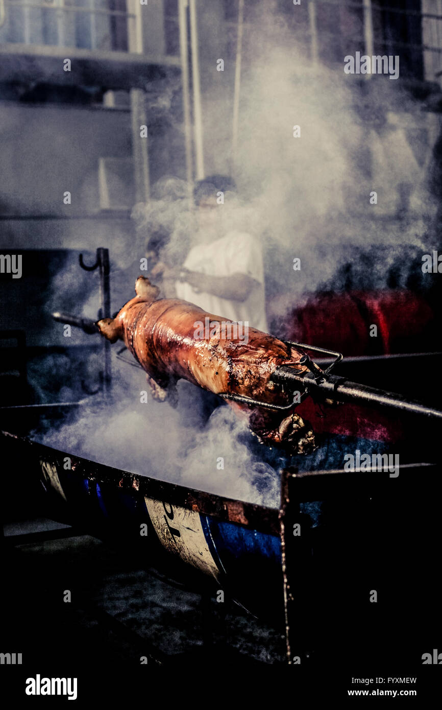 Crew of a container ship spit roasting a pig during a barbeque while at sea Stock Photo