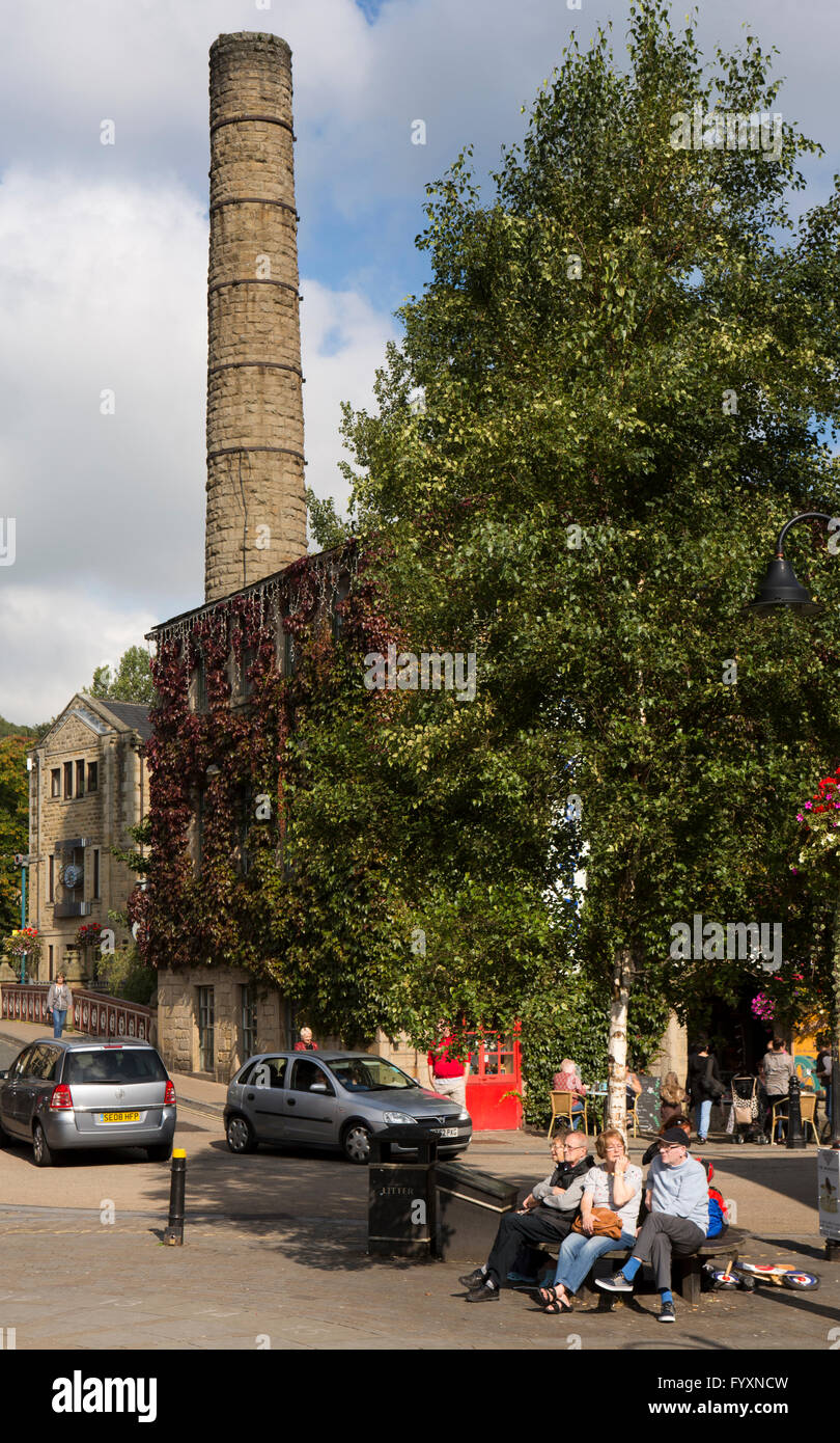 UK, England, Yorkshire, Calderdale, Hebden Bridge, St Georges Square, visitors sat below mill chimney Stock Photo