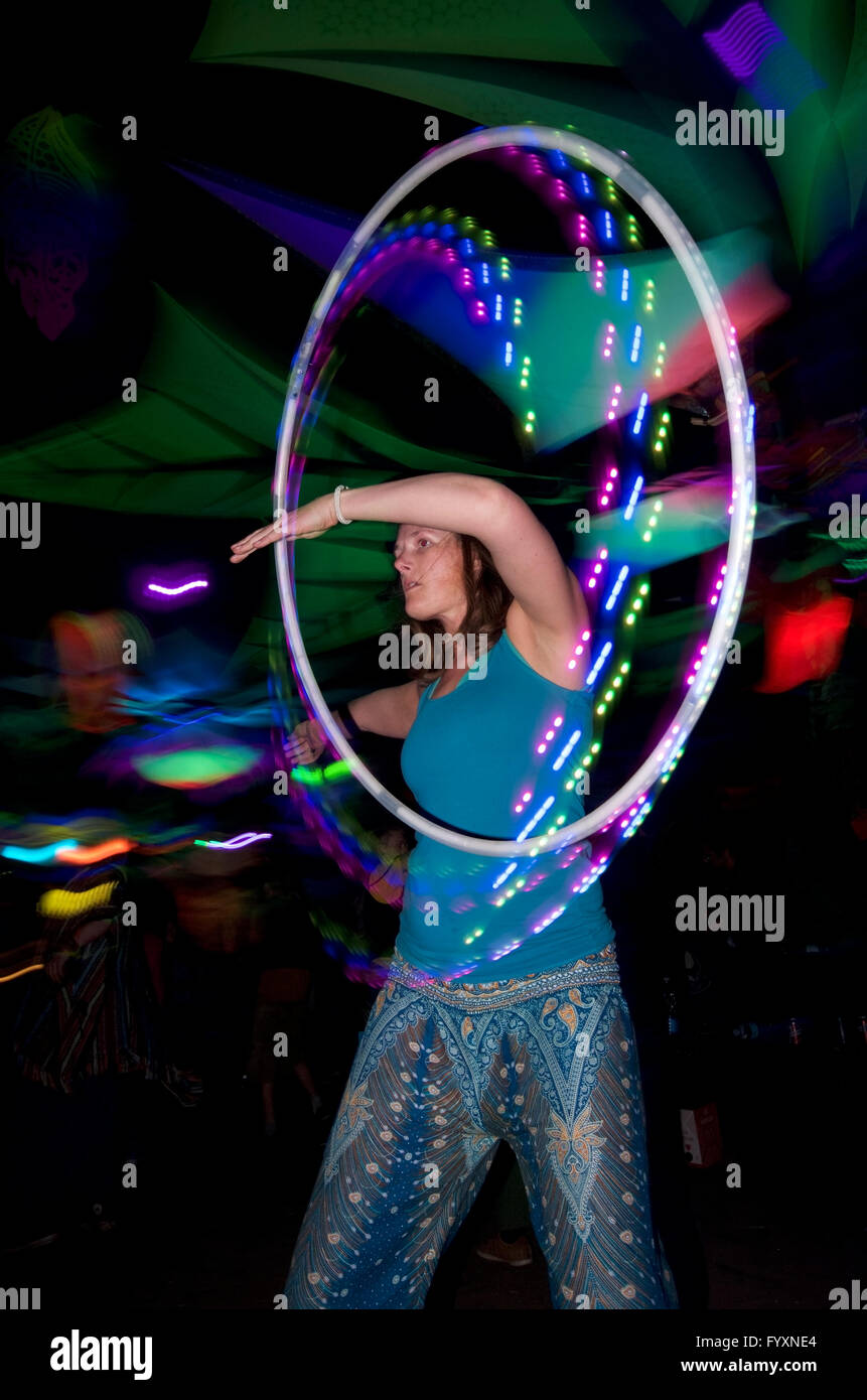 Woman with psychedelic led hula hoop at psytrance festival Stock Photo