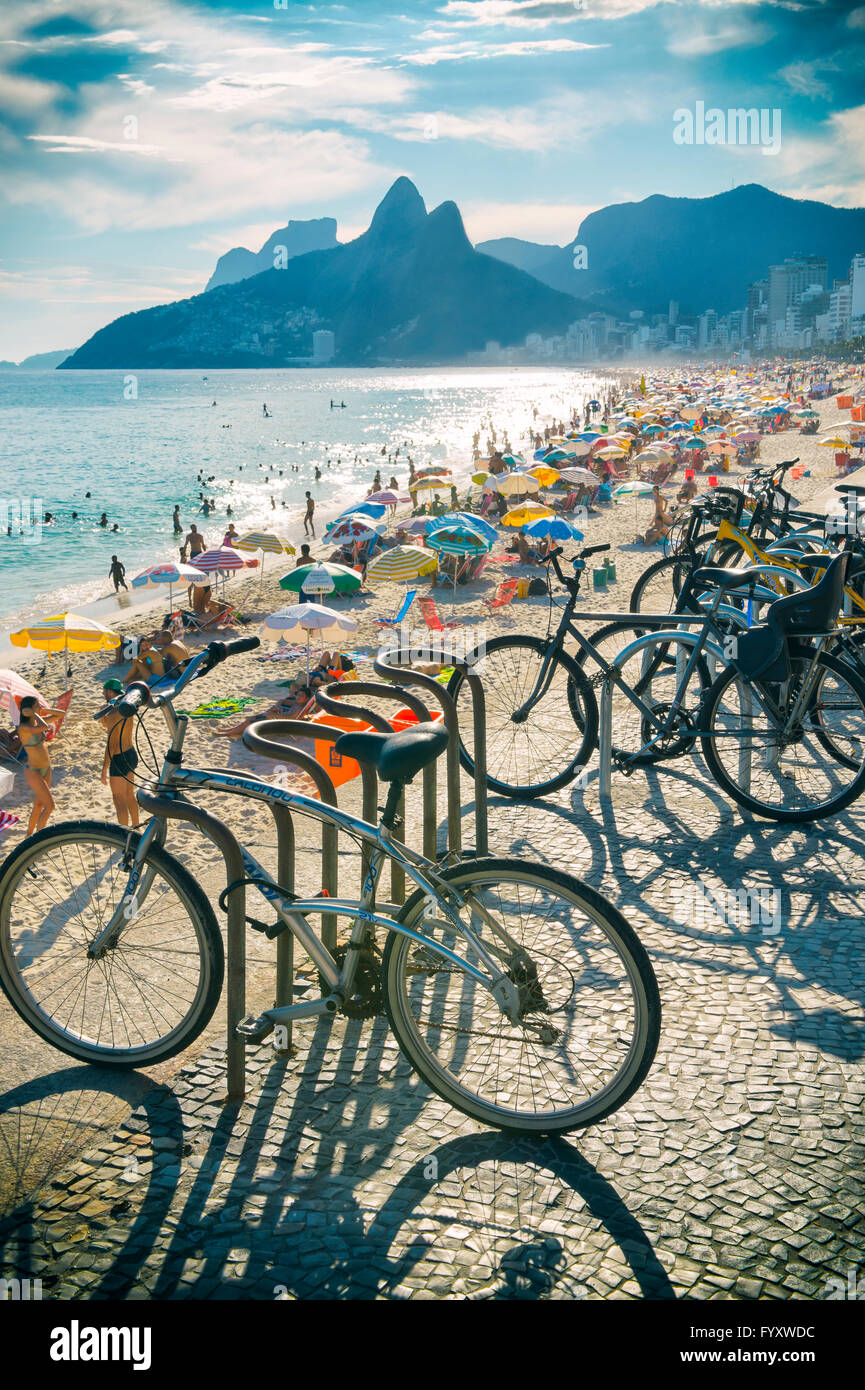 RIO DE JANEIRO - FEBRUARY 21, 2016: Bicycles stand locked above a busy  Ipanema Beach, in a city where theft is a problem. Stock Photo