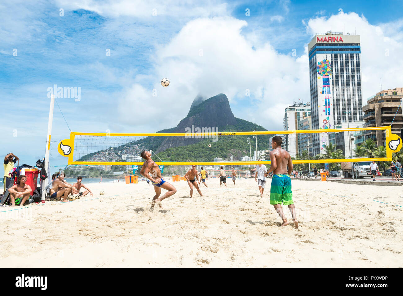 RIO DE JANEIRO - MARCH 17, 2016: Brazilians play a game of futevolei (footvolley), a sport combining football and volleyball. Stock Photo