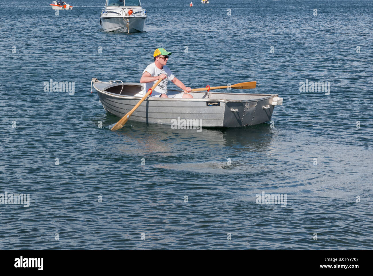 Man rowing a typical aluminium rowing boat or tinny on Lake Taupo in New Zealand's North Island