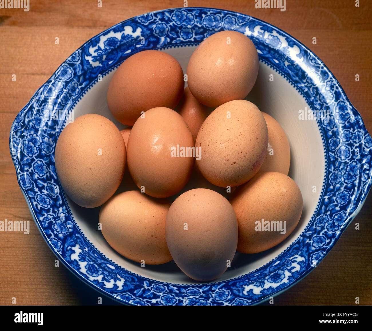 A blue bowl filled up with eggs, inside. Stock Photo