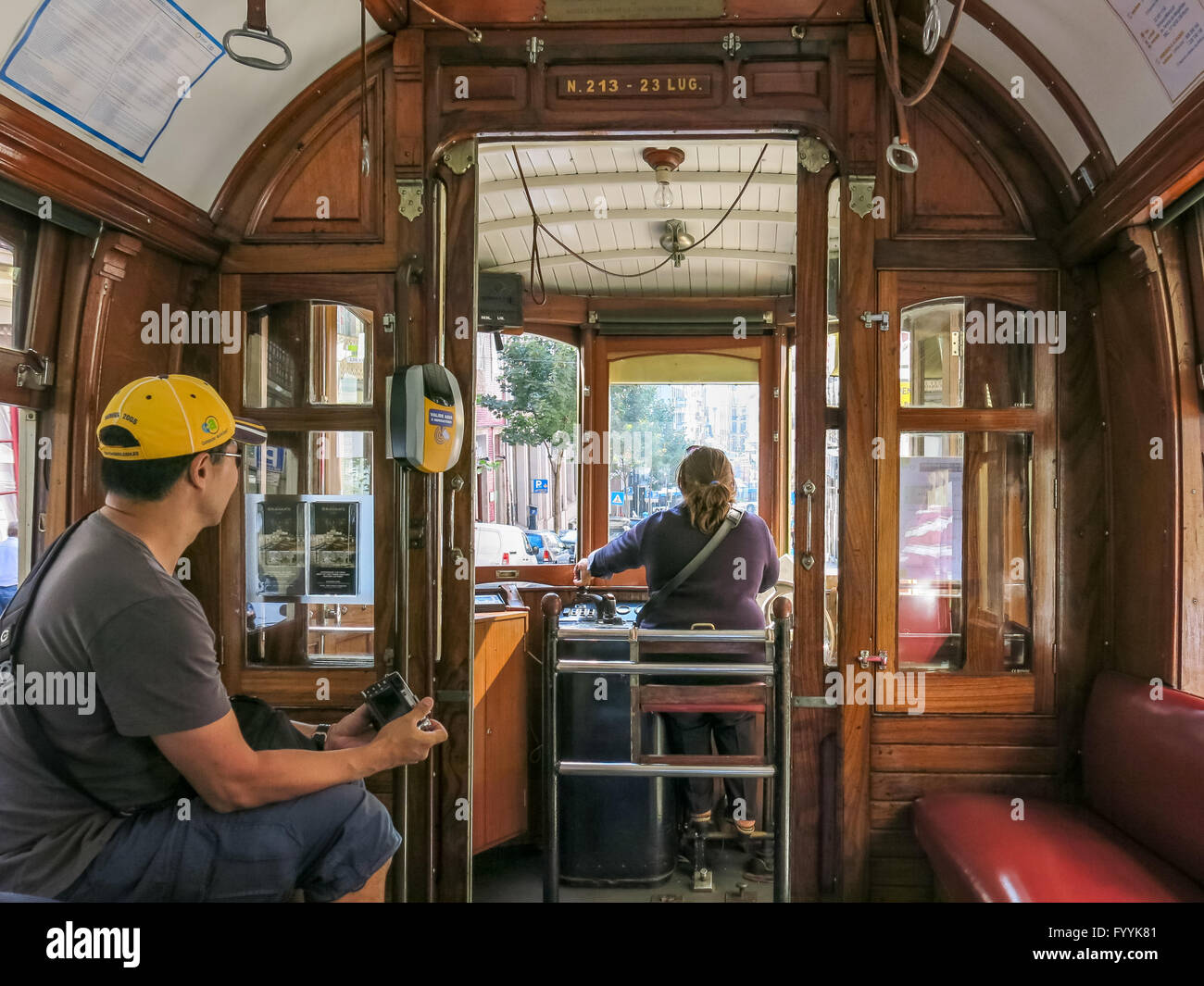 Driver and tourist inside vintage tramcar of heritage tram line in Porto city, Portugal Stock Photo