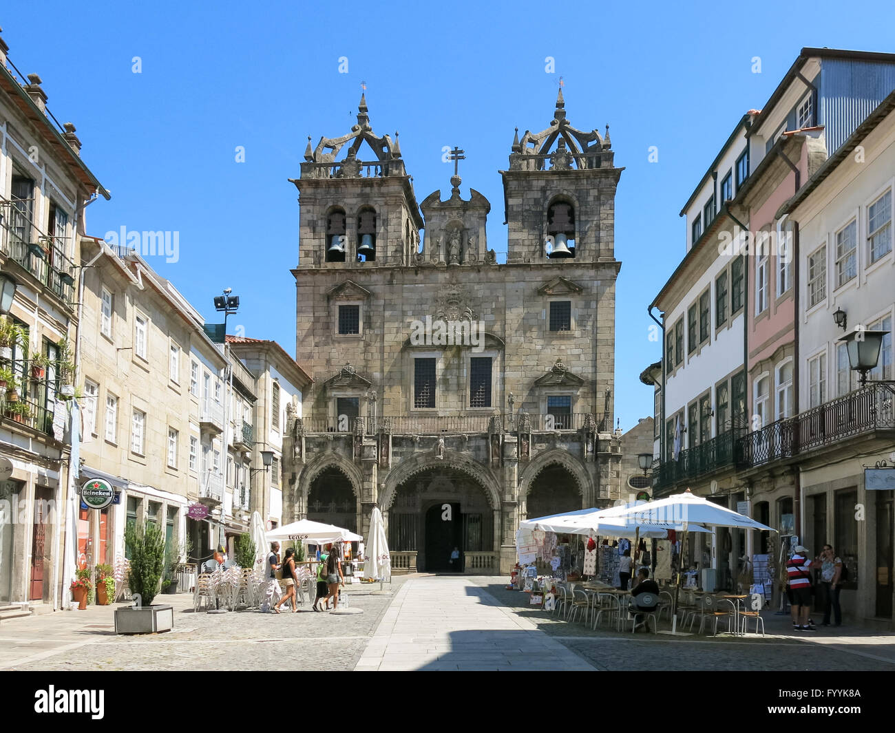 Street scene with people, pavement cafe, souvenir shop and Cathedral Santa Maria in old town of Braga, Portugal Stock Photo