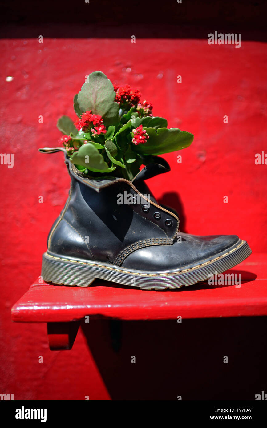 Flowers in boot outside a restaurant in The Albaicin Quarter, old Moorish quarter across the River Darro from the Alhambra Stock Photo