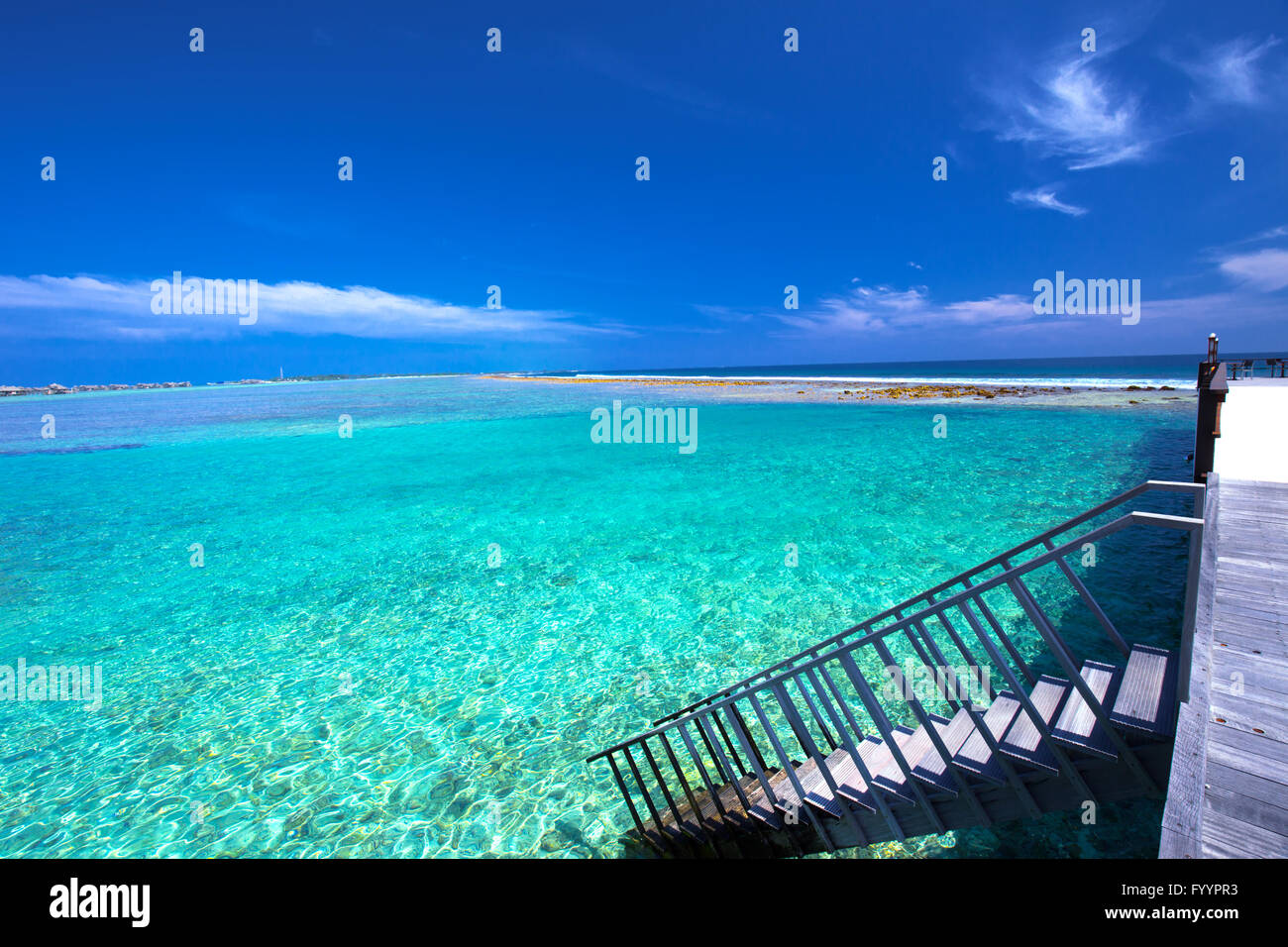 Tropical island with sandy beach with palm trees and tourquise clear water Stock Photo
