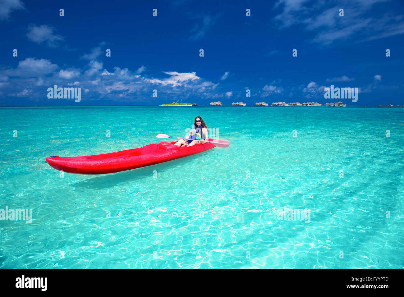 Caucasian woman is kayaking in Maldives Stock Photo