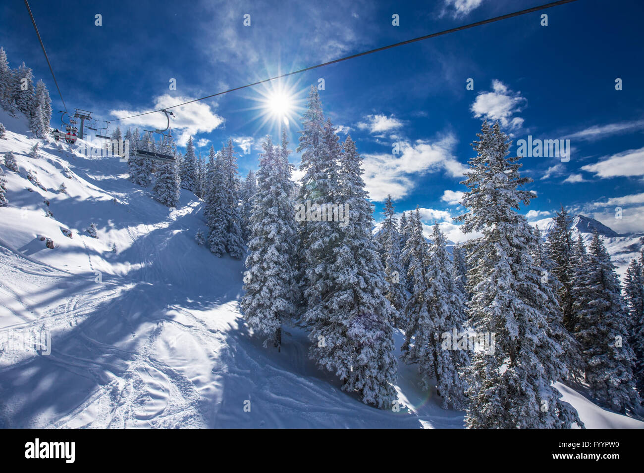 KITZBUEHEL, AUSTRIA, February 17, 2016 - Skiers on ski lift enjoying the view to foggy Alps in Austria and beautiful snowy count Stock Photo