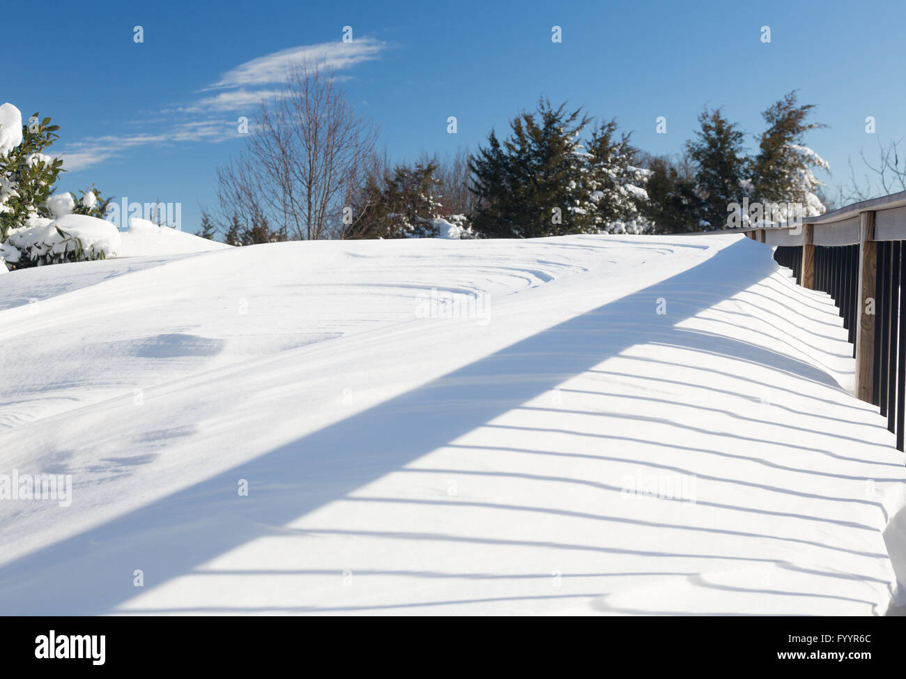 Deep snow in drifts on deck in back yard Stock Photo