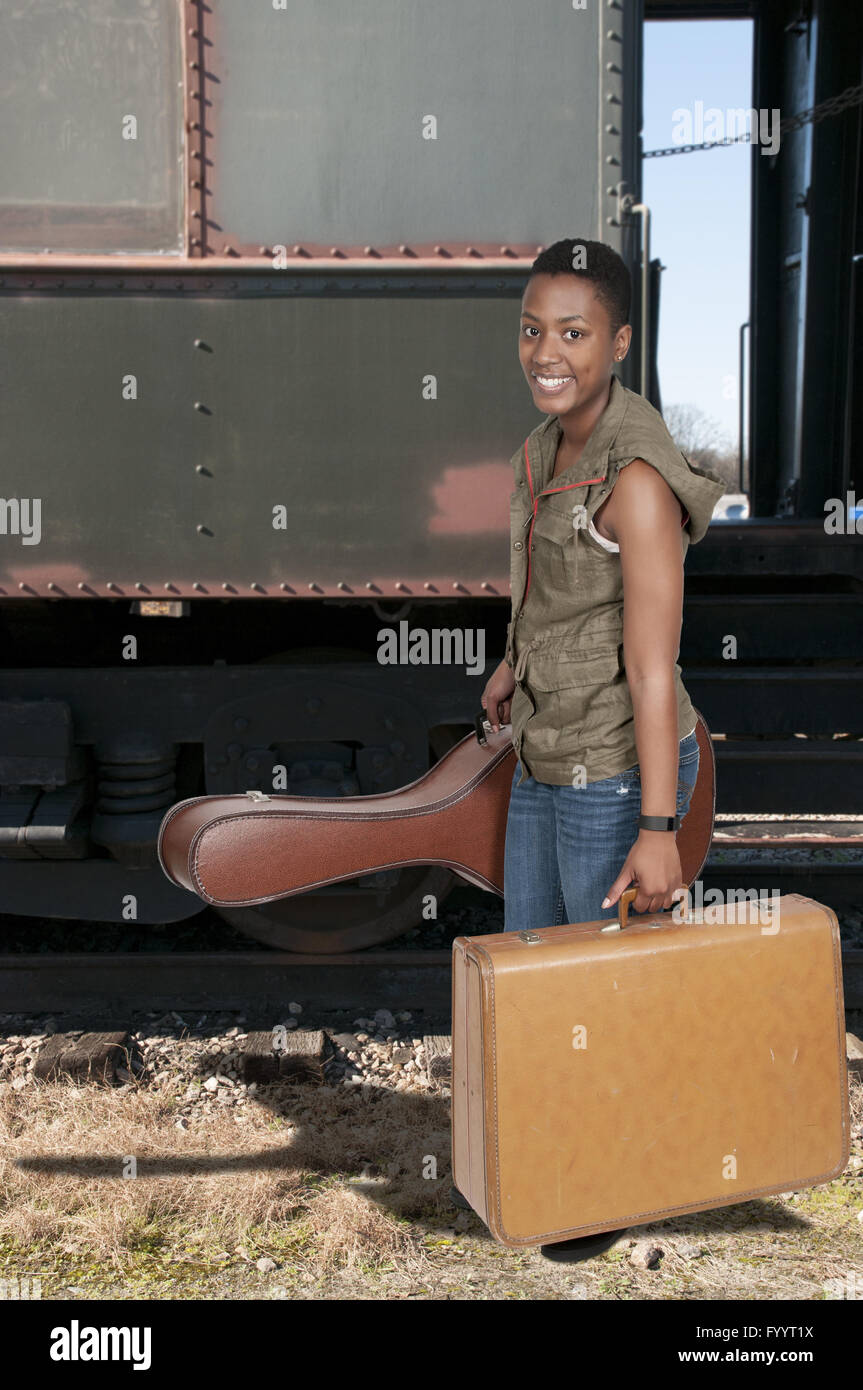 Woman with Guitar and suitcase Stock Photo Alamy