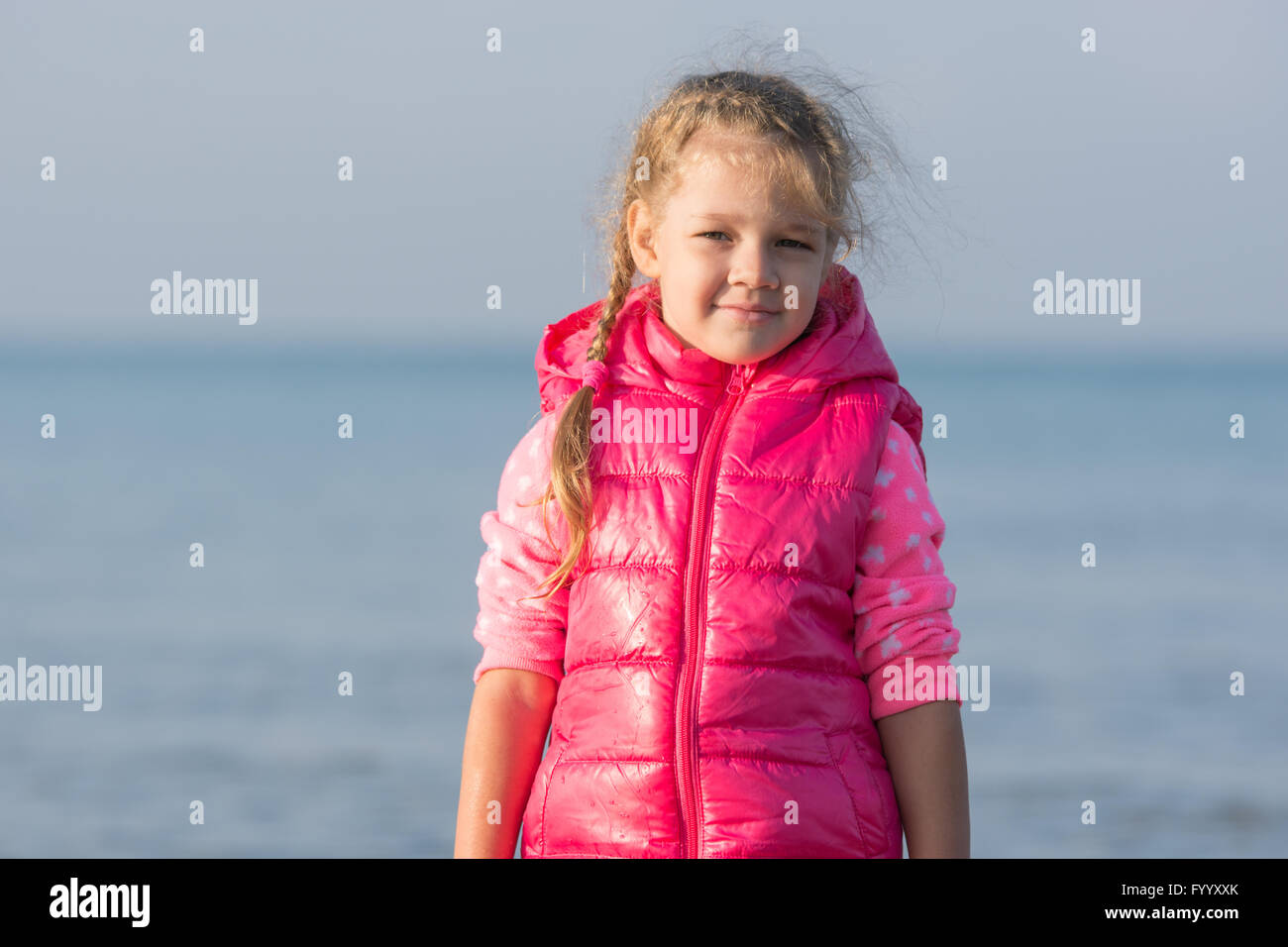 Portrait of the girl in a jacket in the early morning on the beach Stock Photo