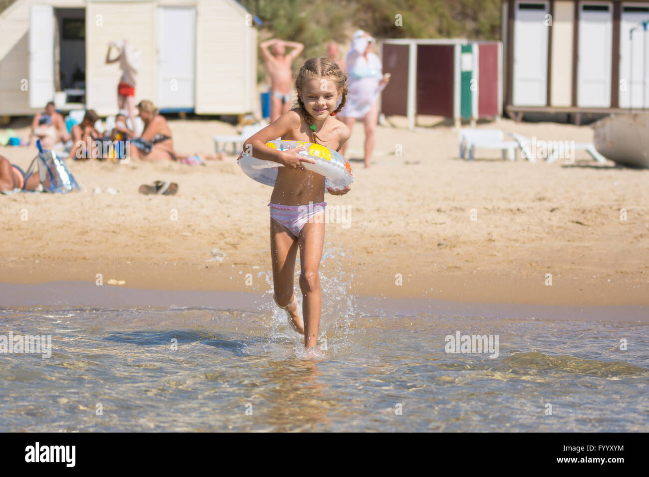 Happy girl running to swim in the sea Stock Photo