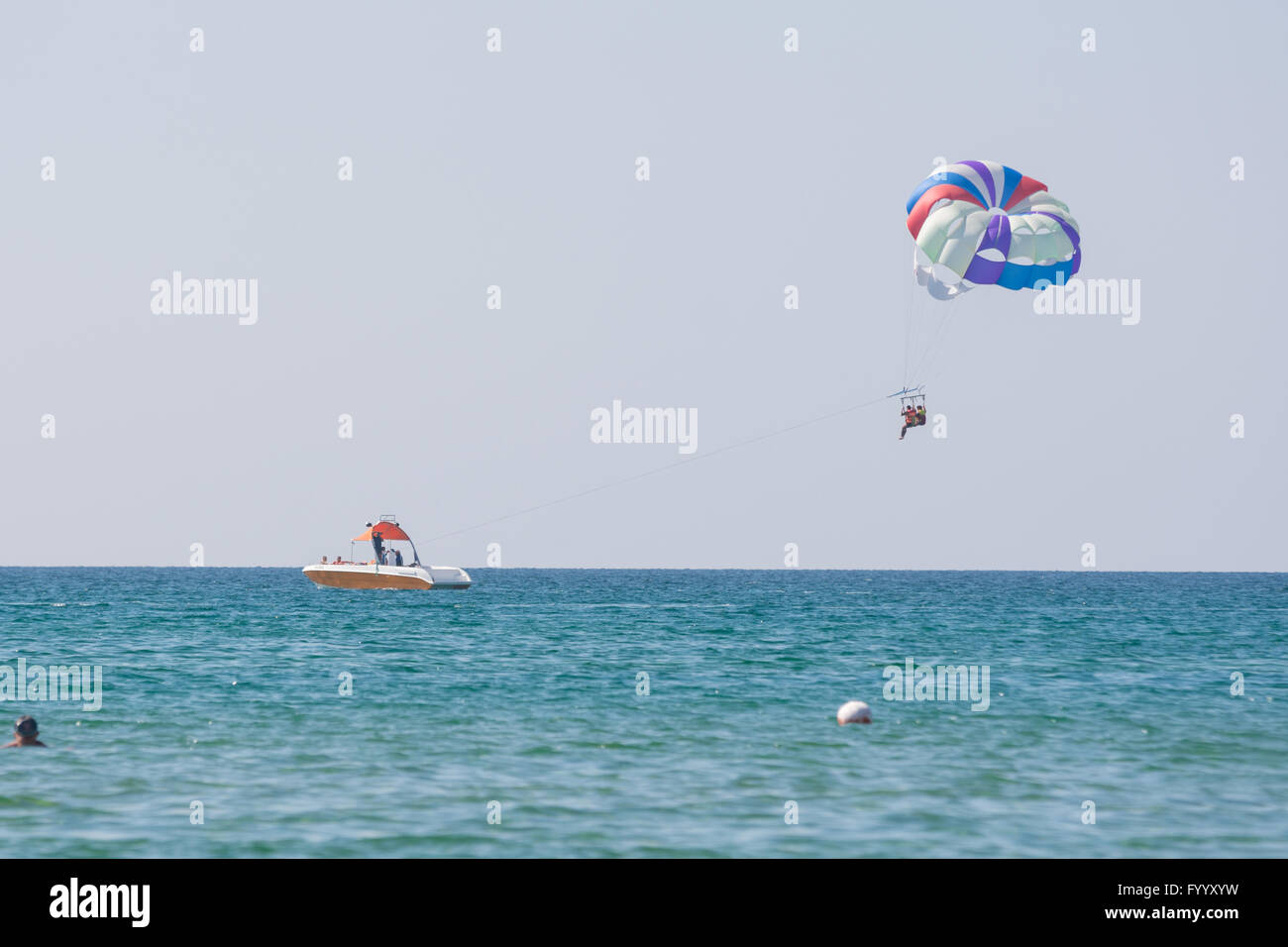 Offshore boat rolls of people on a parachute on the Black Sea coast Stock Photo