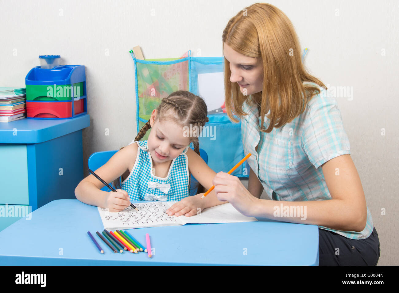The young girl engaged in a five year old girl spelling Stock Photo