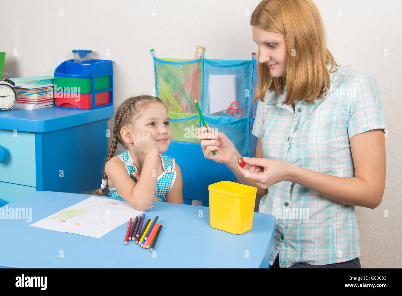 The five-year child looks well if Mom undermined pencil Stock Photo