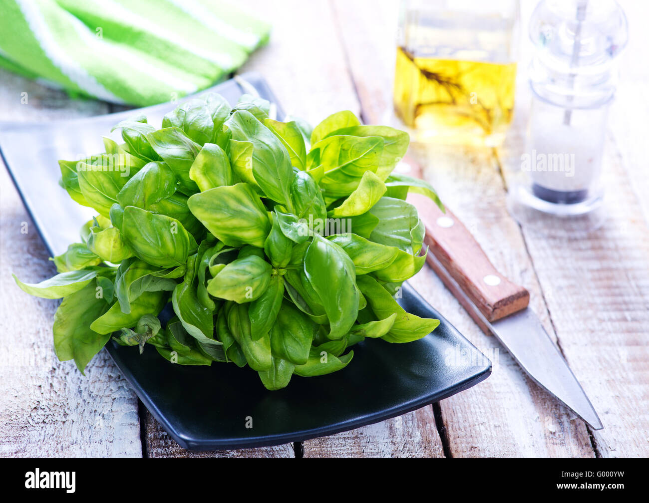 fresh basil on black plate and on a table Stock Photo - Alamy