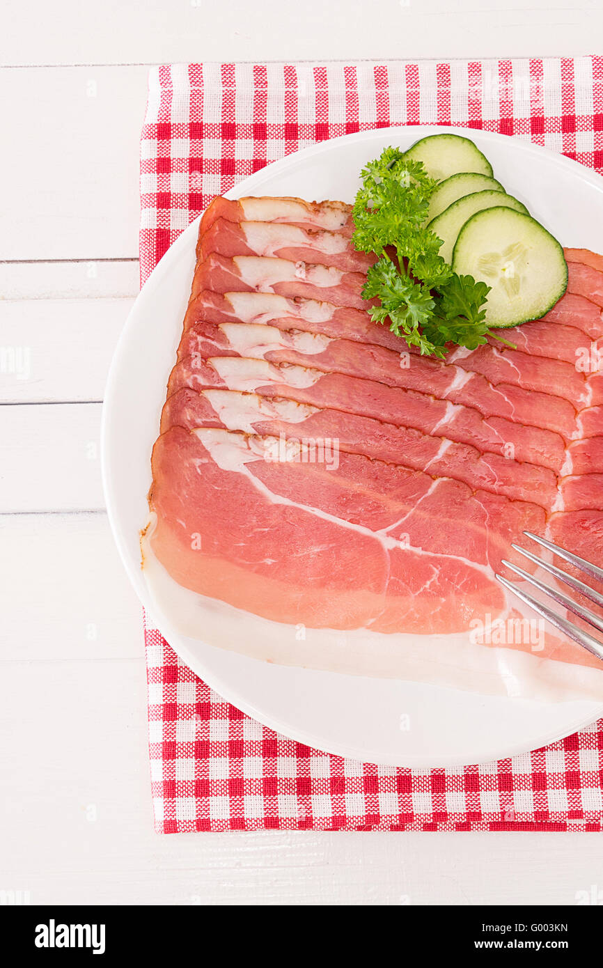 Ham cut up into slices is on a plate Stock Photo