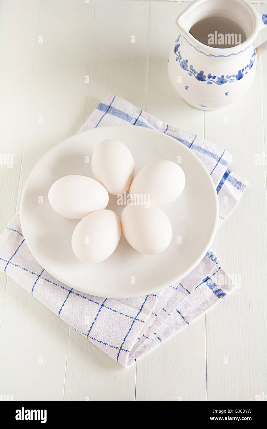 Raw eggs lie on a plate Stock Photo