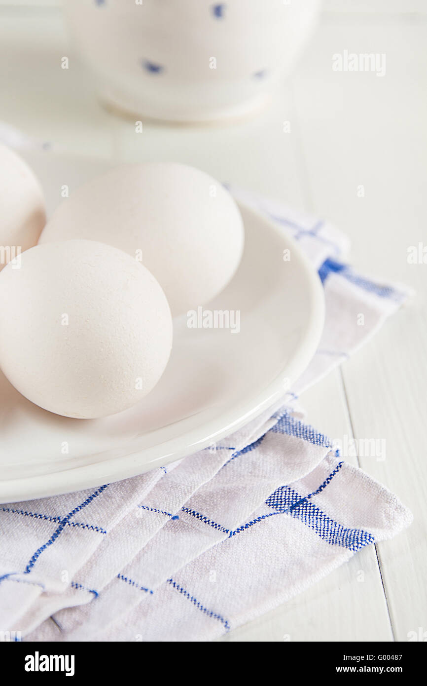 Raw eggs lie on a plate Stock Photo