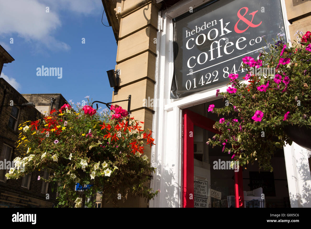 UK, England, Yorkshire, Calderdale, Hebden Bridge, Albert Street, Hebden Cook and Coffee Co floral hanging baskets Stock Photo