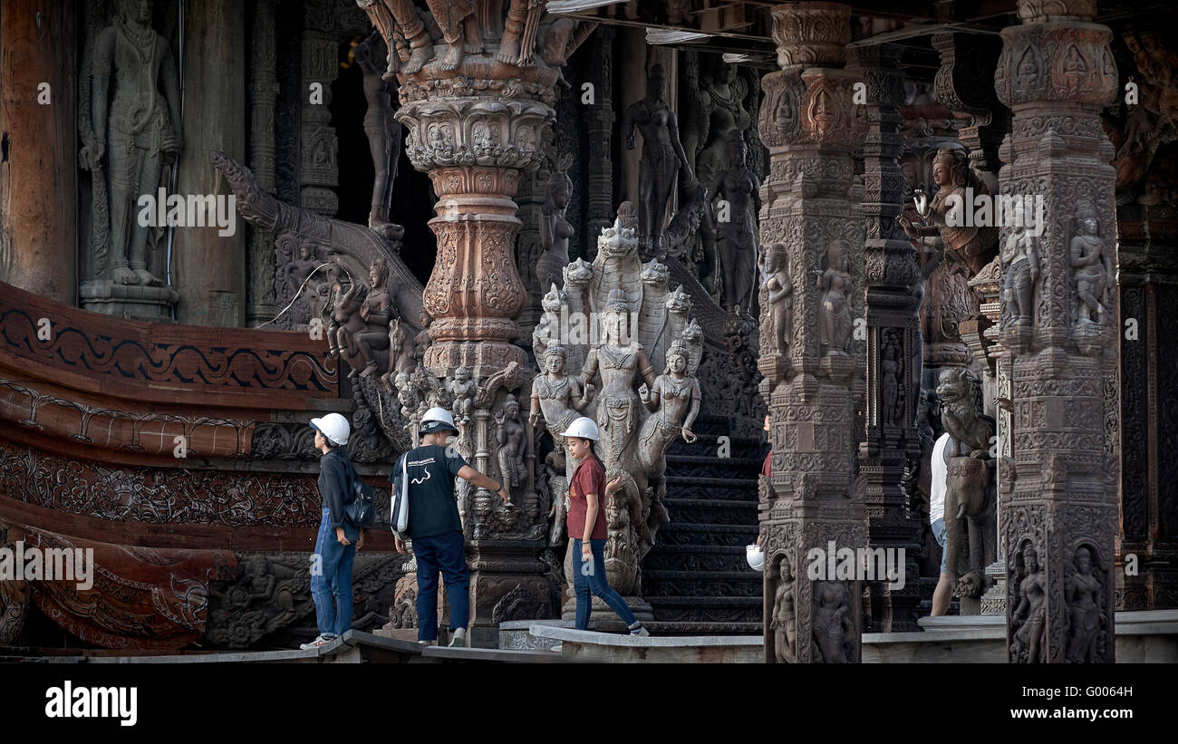 People hard hat. Group of tourists wearing mandatory hard hats at the Sanctuary of Truth Hindu temple. Pattaya Thailand S. E. Asia. Stock Photo