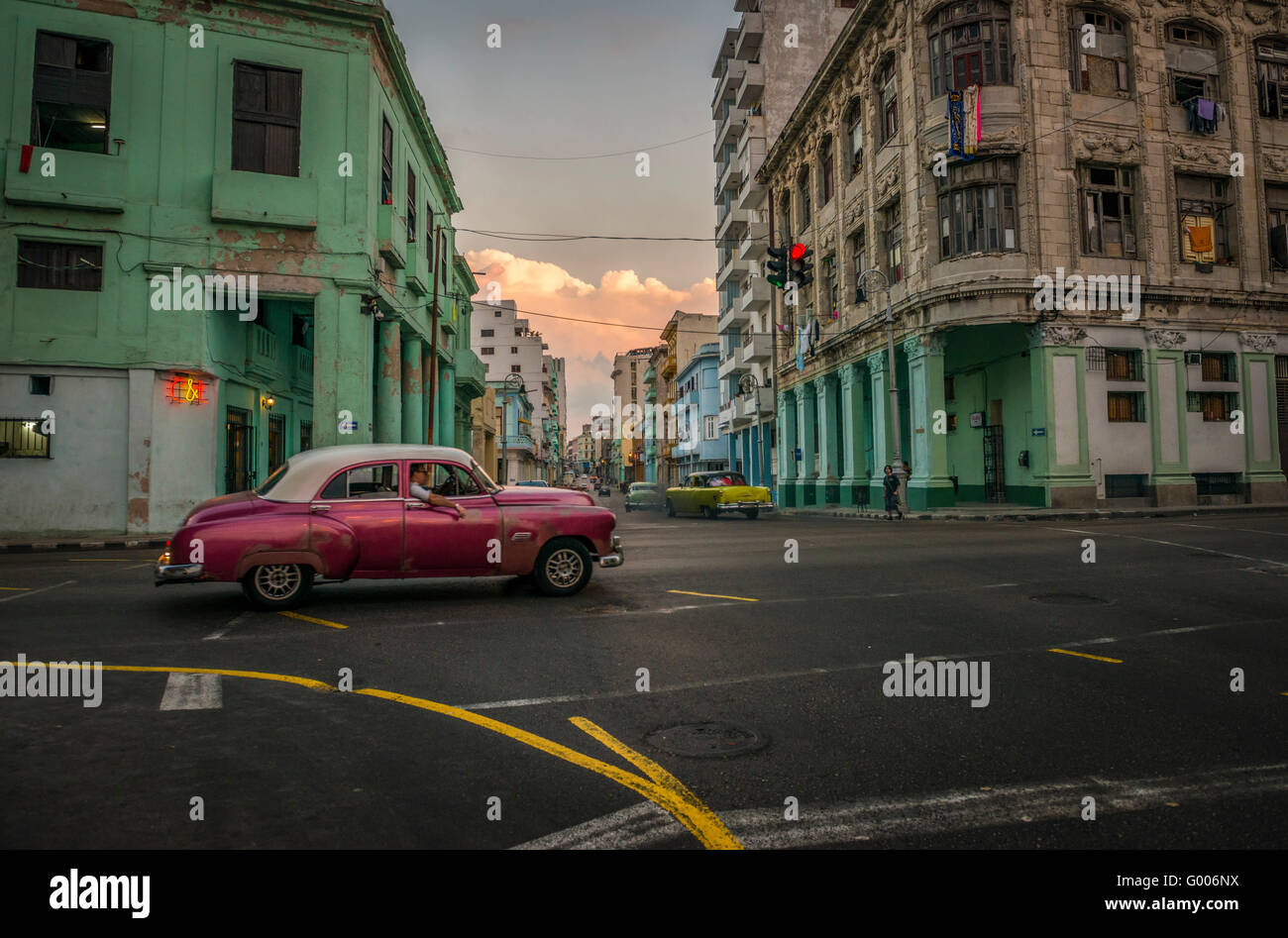 A pearlescent burgundy vintage car passes through the intersection of Galiano and San Lazaro in Centro Habana, La Habana, Cuba Stock Photo