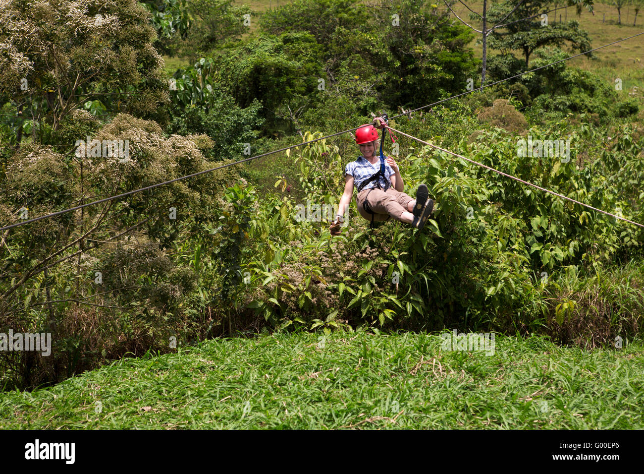A woman zip lining at Sarapiqui in Costa Rica. Stock Photo