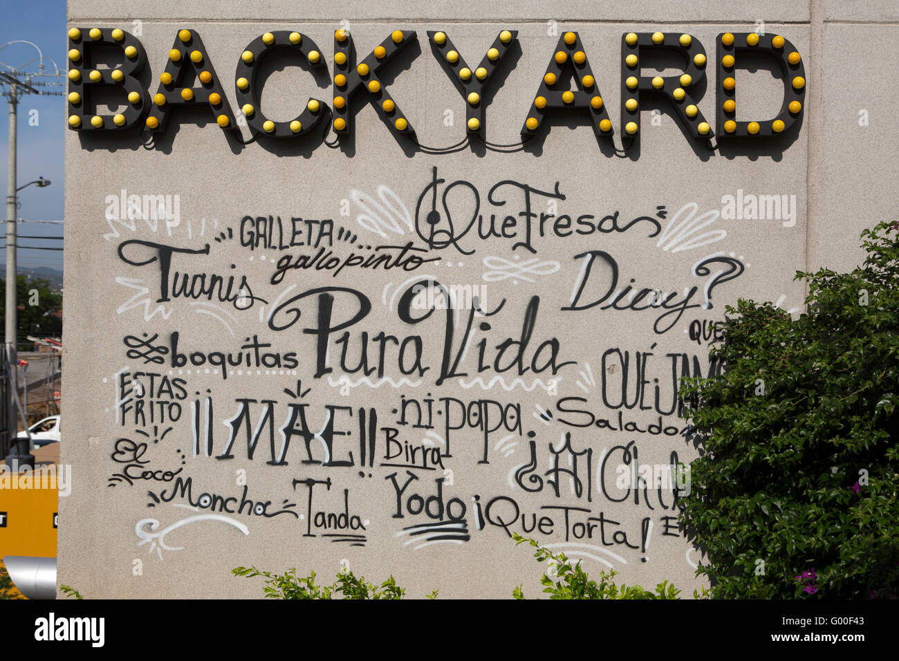 Phrases and words used in Costa Rican Spanish on the wall of the Backyard at the Aloft Hotel in San Jose. Stock Photo