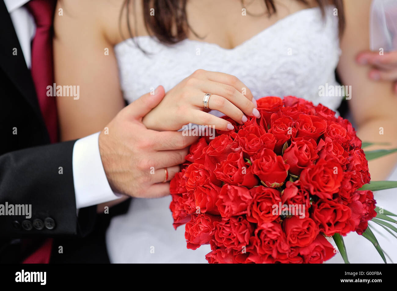 Hands of bride and groom with rings on wedding bouquet Stock Photo - Alamy