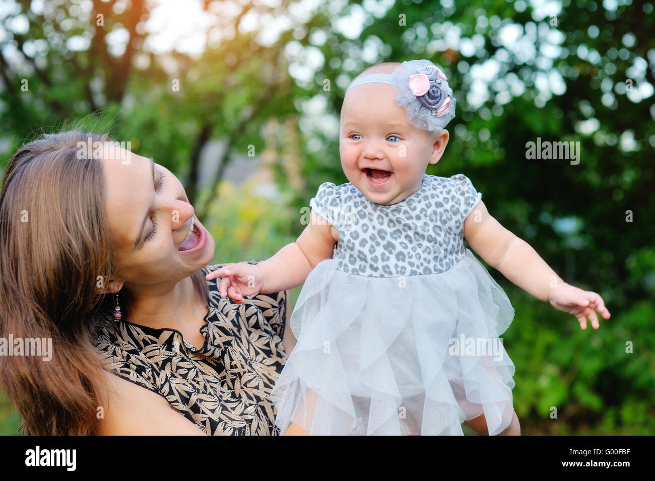 Happy mother and daughter smiling outdoors in a park Stock Photo