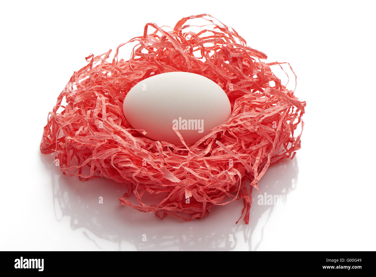 Single white chicken egg in pink paper nest isolated on white background Stock Photo