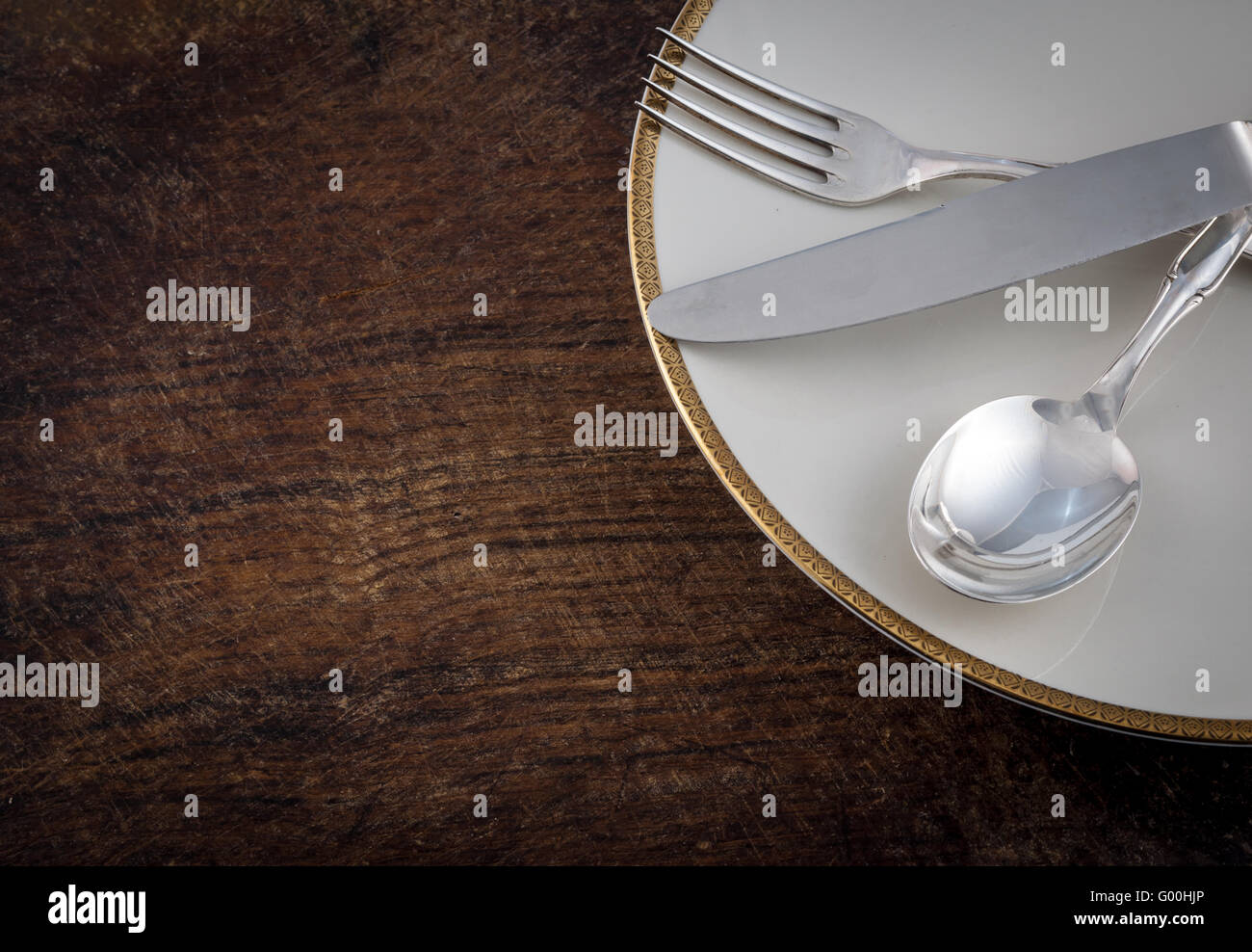 Close up Silver Spoon, Fork and Knife Tied on White Dish, on wooden talbe Stock Photo