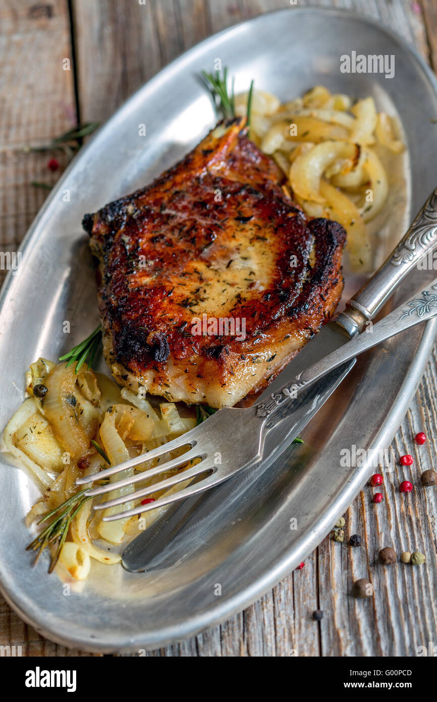 Pork chop with rosemary and fried onions. Stock Photo