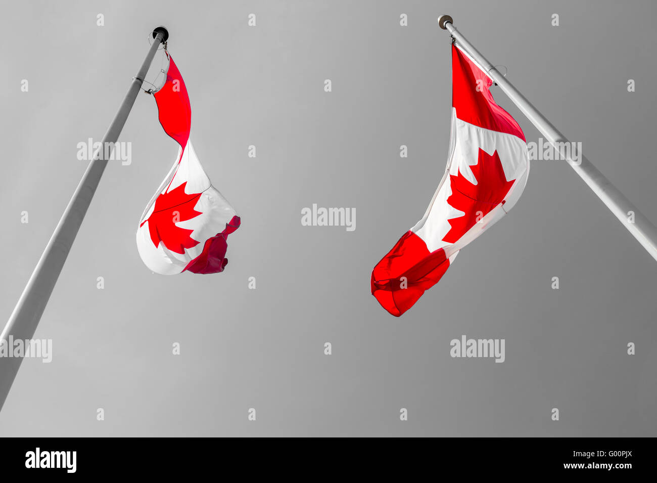 Two Canadian flags waving over grey sky Stock Photo