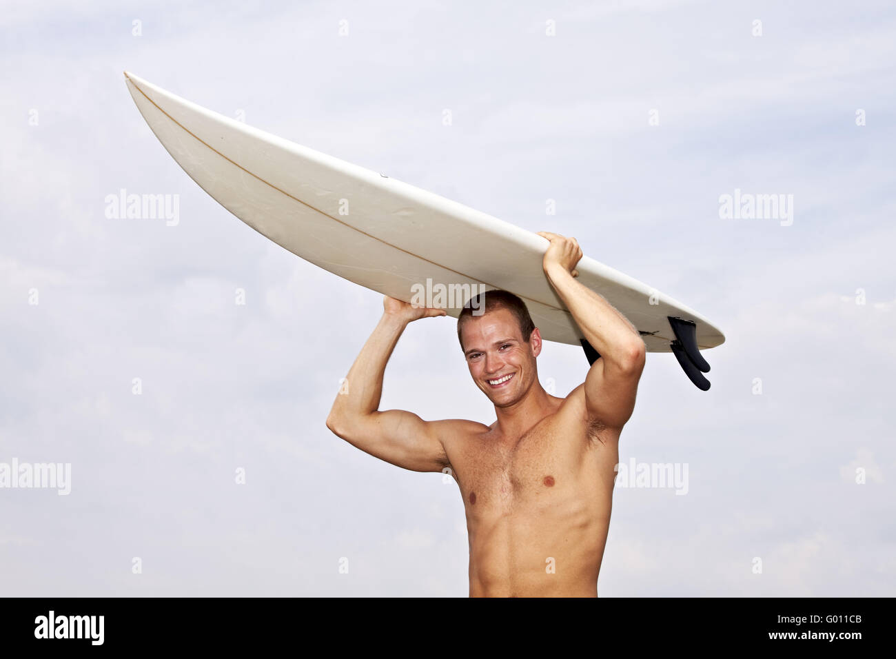 young man holding a surf board outdoors Stock Photo