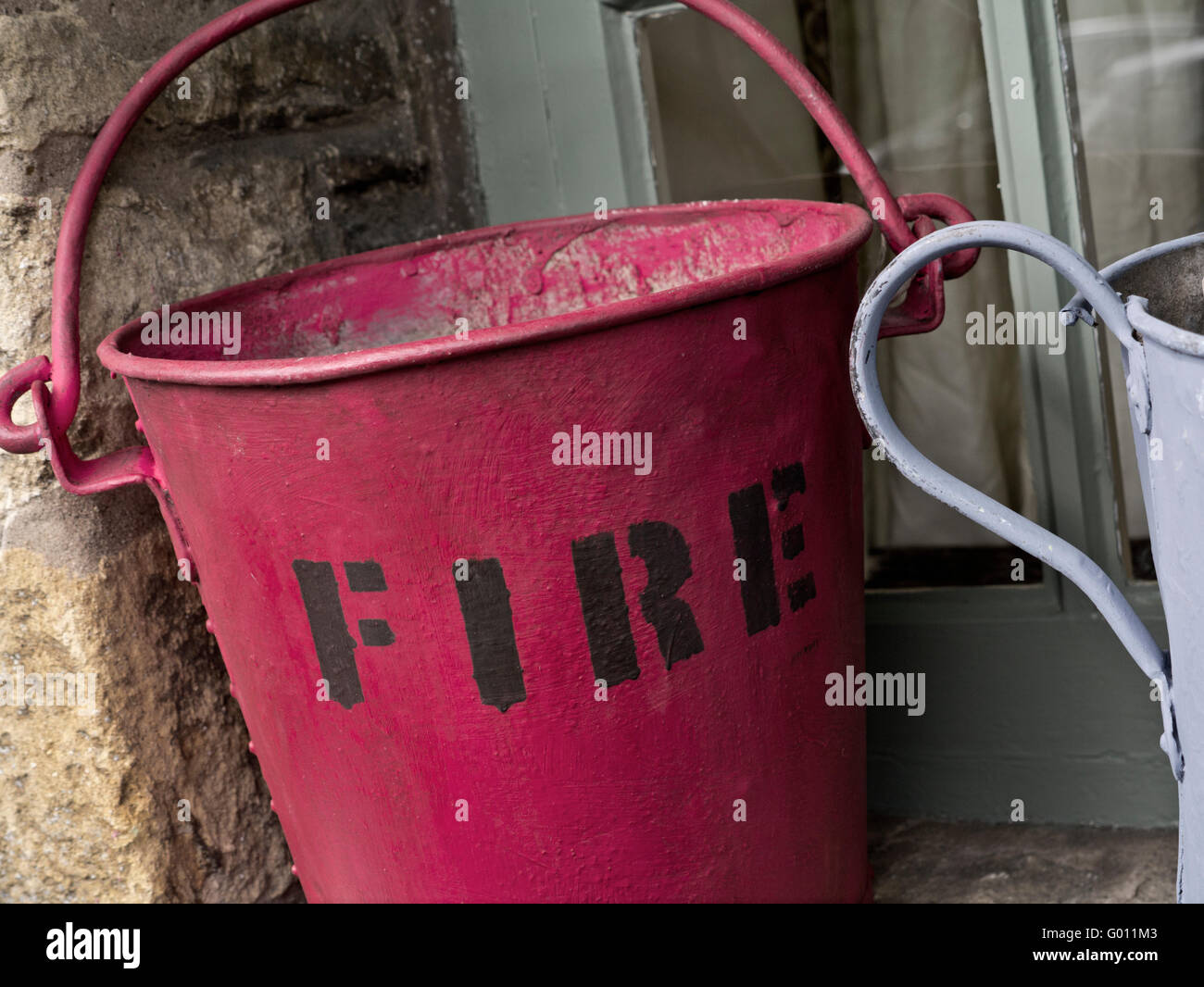 Typical old fire bucket on window ledge used as an outdoor feature Stock Photo