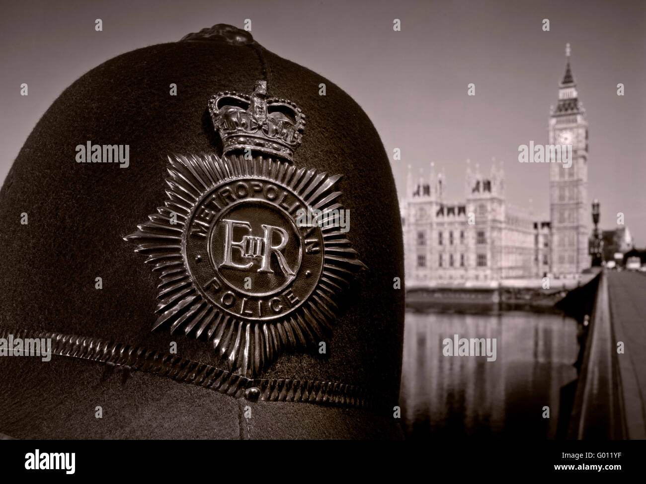 Police LONDON 1960's Metropolitan police helmet close view on historic retro helmet with Houses of Parliament & River Thames behind Westminster UK B&W Stock Photo