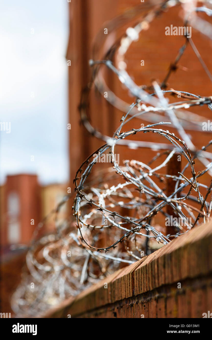 Razor wire on premises alongside the Leeds and Liverpool Canal in Wigan Greater Manchester UK Stock Photo