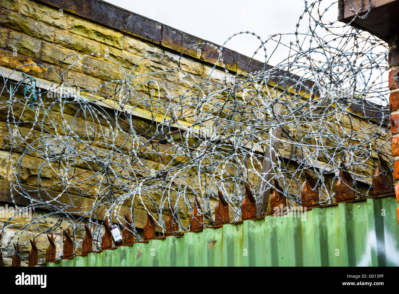 Razor wire on premises alongside the Leeds and Liverpool Canal in Wigan Greater Manchester UK Stock Photo