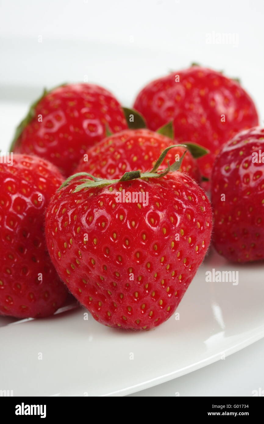 a bunch of strawberries on a plate over white background Stock Photo ...