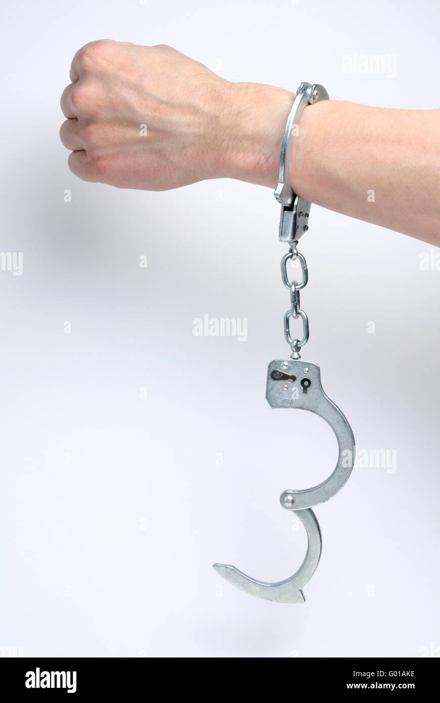 Handcuffs on man's wrist Stock Photo