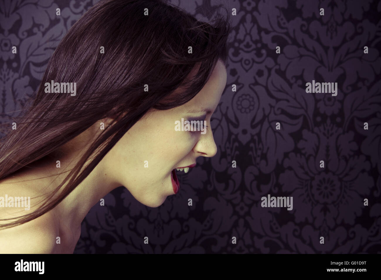 closeup of woman screaming on stylish wallpaper background Stock Photo
