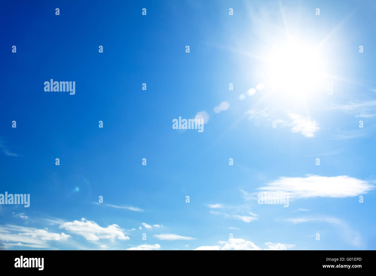 bright blue sky with the sun causing lens flare Stock Photo