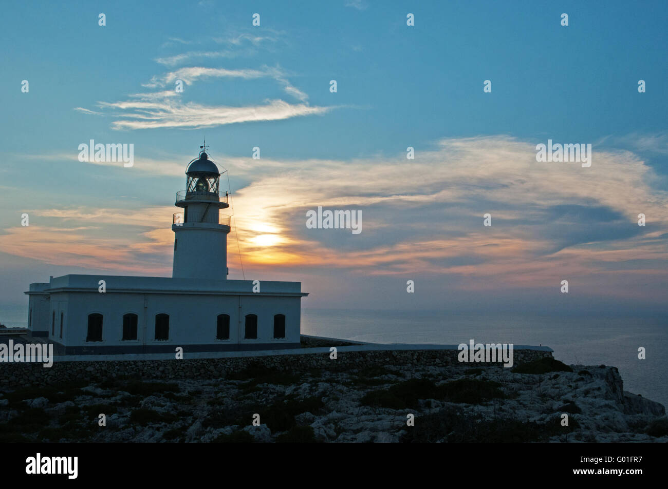 Minorca, Balearic islands, Spain: sunset at Cap de Cavalleria lighthouse, built on a cape that was the scene of numerous shipwrecks throughout history Stock Photo