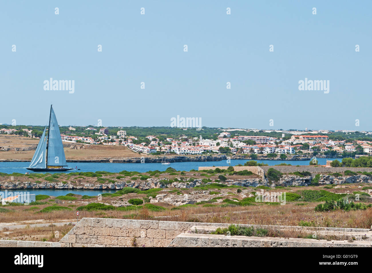 Menorca, Balearic Islands, Spain, Europe: a sailboat approaching in the port of Mahon seen from the Fortress of La Mola Stock Photo