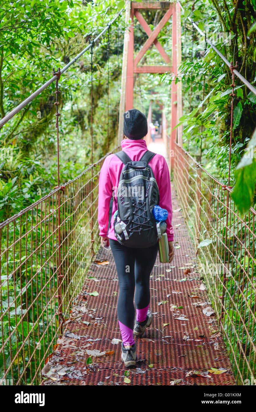 female mountaineer crossing a suspension bridge Stock Photo