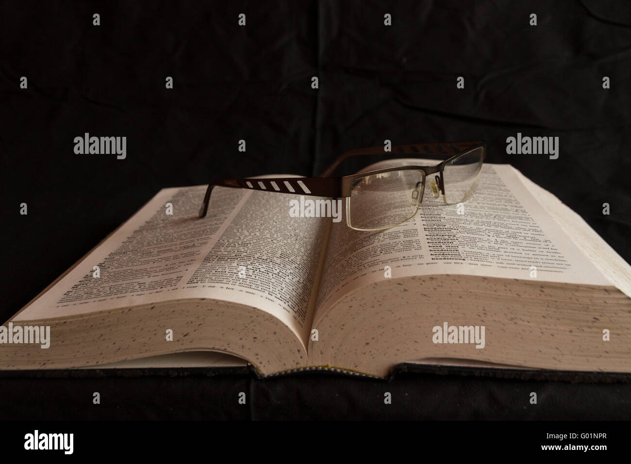 English dictionary with a pair of glasses resting on it Stock Photo Alamy