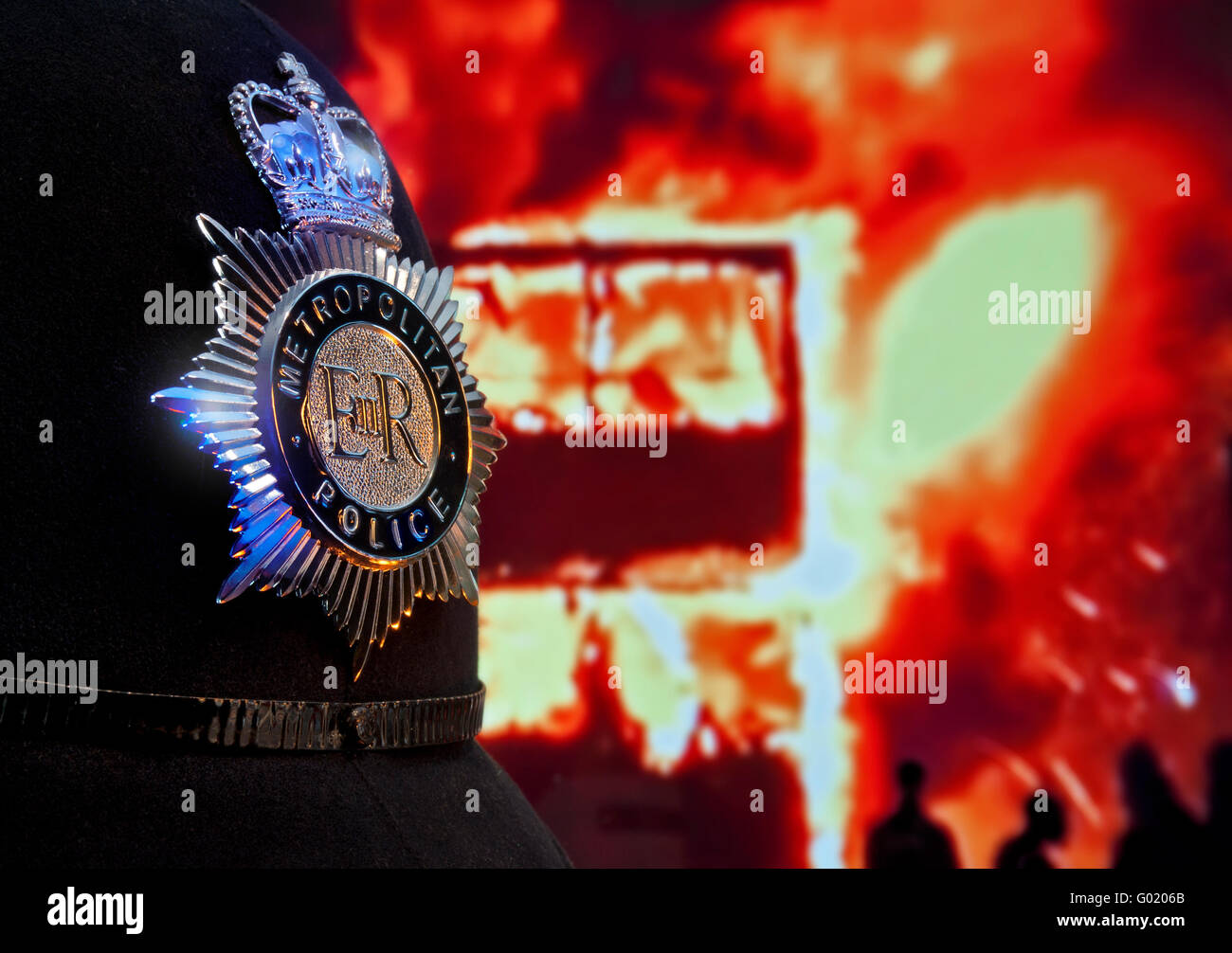 Metropolitan police constable's helmet and badge with fire bombed London bus in flames behind Concept Law Order Security Anarchy Terrorism Looting Stock Photo