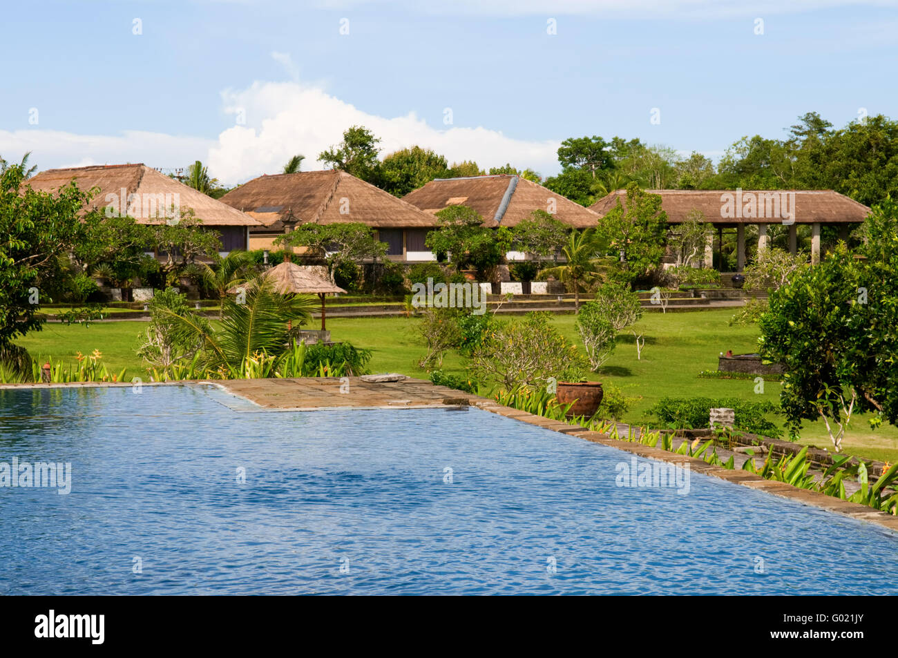 Villas and swimming pool in green field of India Stock Photo